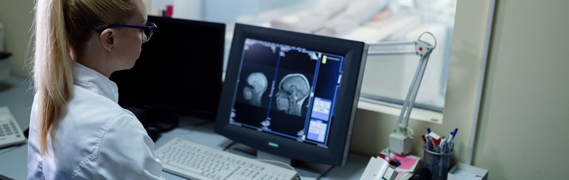 Ärztin sitzt am Computer und wertet Röntgenbilder aus