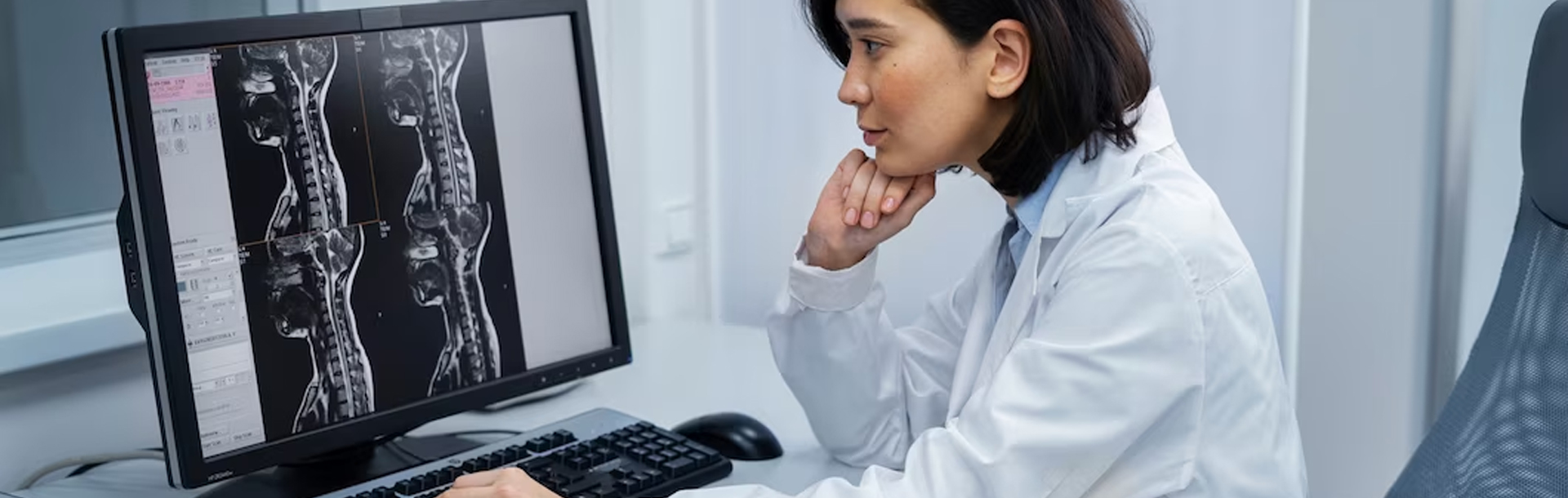Ärztin sitzt am Computer und wertet Ergebnisse aus
