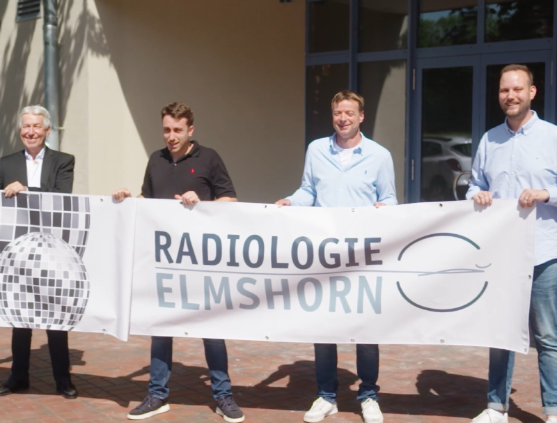 Vier Männer halten einen Banner mit der Aufschrift Radiologie Elmshorn